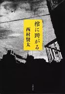 棺に跨がる