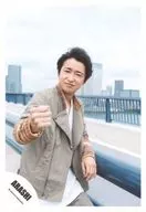 Arashi / Satoshi Ohno / Upper body / Costume gray-beige brown white / Fist on the right hand / Handrail on the left hand / Leaning against the body / Right side of the body / Outdoor background / Road / "Power of the Paradise" PV & Jacque photo / Official Official photo