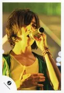 Kansai Johnnys Jr. / Yu Arimoto / Live photo ・ Bust up ・ Costume green yellow ・ Right hand chest ・ Left hand microphone ・ Body facing right ・ Light yellow / Official Official photo