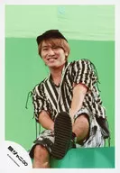 Kanjani Eight / Akihiro Yasuda / Knee-Up, Sitting, Costume Black and White Stripe Pattern, Cap, Left Foot Up, Body Diagonal, Show Teeth, Green Background / "Panorama" PV & Jacque Shooting / Official Official photo