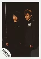 KinKi Kids / Domoto Go ・ Domoto Koichi / Knee-High ・ Costume Black ・ Body Left Facing ・ Both Hands Below ・ Eyes Lower Left ・ Background Black / Official Official photo