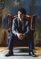 伊藤武雄/全身・衣装グレー・青・座り・両手重ね・口閉じ・椅子・背景青/DVD「女王の戦略」予約特典生写真