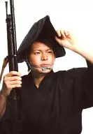 Takashi Sekine / Bust up / Costume black / Right-handed gun / Left-handed headgear / Background white / Stage "BARAGA - Oniki"