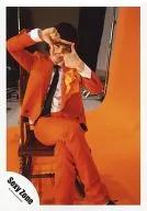 SeXyzone / Ken Nakajima / Whole body, sitting, costume orange, tie black, square with both hands, legs set, chair, background orange / Official Official photo