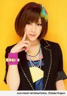 Buono! / Miyabi Natsuyaki / Upper Body / Costume Black / Necklace Colorful / Right Hand Index Finger Cheek / Left Hand Lower / Mouth Closed / Background Yellow / Official Official photo