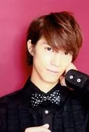 Kyosuke Hamao / Bust Up / Costume Black / Bow Tie / Left Hand Cheek / Mouth Closed / Background Red / Event Product Sales Official photo