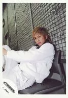 J-Friends / Tsuyoshi Morita / Above-the-knee ・ Costume white ・ Sitting ・ Left hand and right foot ・ Background fence ・ Grey / Official Official photo