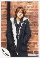 KAT TUN / Tatsuya Ueda / Above-the-knee ・ Costume black ・ White ・ Fur ・ Pocket with both hands ・ Background brick / Official Official photo