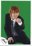 NEWS / Yuya Tegoshi / Knee-Up / Sitting / Suit black / Shirt white / the left fingers Holder / Wink / Background green / Official Official photo