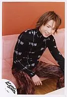 KinKi Kids / Koichi Domoto / Above the knees ・ Clothes black ・ Sitting on the sofa ・ Smiling ・ Background orange / Official Official photo