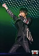 KinKi Kids / Koichi Domoto / Live photo, above knees, costume black silver, right hand fist, left hand microphone, green background, no frame, logo "KinKi you" / Kinki Kids Emergency Nationwide Tour KinKi you Concert.