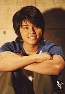 NEWS / Yuya Tegoshi / Upper body / Shirt white / Sleeves blue / Both hands crossed / Pants khaki color / Eyes right / Smile / Background concrete / Jonny's Film Festa 2005 / Official Official photo