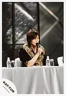 KAT TUN / Hitoshi Akanishi / Upper body / Black jacket / Fur collar / Right hand microphone / Silver table / PET bottle / Body facing right / Official Official photo