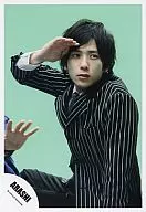 嵐/二宮和也/衣装黒・ストライプ・膝上・座り・右手顔・背景緑/公式生写真