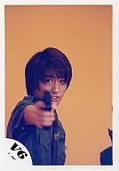 V6 / Ken Miyake / Bust up / Khaki Shirt / Right Hand Gun / Orange Background