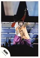 NEWS / Takahisa Masuda / Shirt Orange / Above Knee / Eye Point Left / Right Hand Microphone / Person Behind / Official Official photo