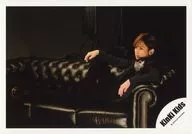 KinKi Kids / Koichi Domoto / Horizontal, Whole body, Costume black, white, Polka dot pattern, Sitting, Facing left, Standing on right knee, Sofa, Background black / Official Official photo