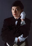 * Takuya Nihei / with handwritten signature, upper body, costume black, white, left hand up, face left, background grey / stage "Sleepless Sheep"