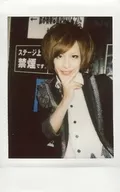 TOON-FACTORY / Hikaru. / Upper body ・ Costume black / white ・ Right hand chin ・ Sandwiched between two fingers ・ Body tilted to the left ・ Background wall black / Raw Cheki